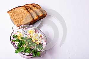 Traditional Russian layered betroot and herring salad under a fur coat in glass jar, white background, selective focus photo