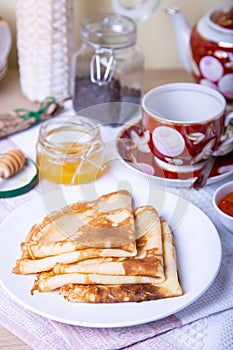 Traditional Russian pancakes with honey, sour cream and jam.