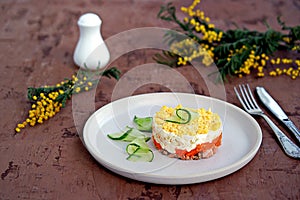 Traditional Russian salad Mimosa with boiled pink salmon, carrots, onions and eggs