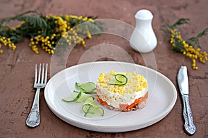 Traditional Russian salad Mimosa with boiled pink salmon, carrots, onions and eggs