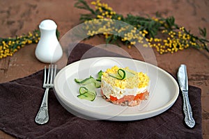 Traditional Russian salad Mimosa with boiled pink salmon, carrots, onions and eggs