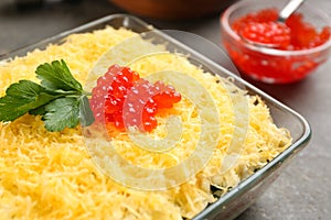 Traditional russian salad Mimosa on grey table, closeup