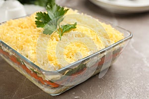 Traditional russian salad Mimosa served on marble table, closeup