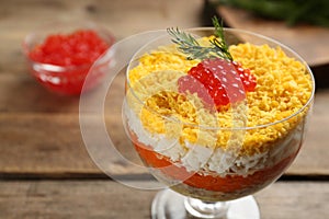 Traditional russian salad Mimosa served on wooden table, closeup