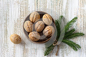 Traditional Russian  shortbread nuts with boiled condensed milk, sprinkled with powdered sugar in a wooden bowl on a wooden