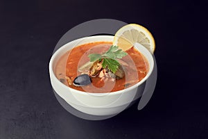 Traditional Russian soup Solyanka cooked with meat, sausages, salted cucumbers and olives