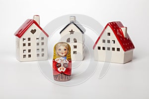 Traditional Russian souvenir Matryoshka on the background of decorative houses