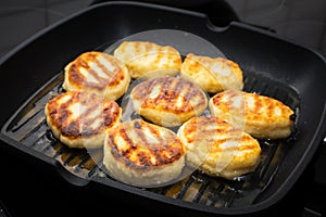 Traditional Russian sweet syrniki cottage cheese pancakes fried in the frying pan