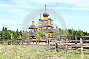 Traditional russian wooden church with domes in nature landscape. Architecture in the Orthodox religion