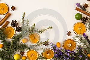 Traditional rustic Christmas background with Mediterranean theme: cinnamon sticks, pine cone, star anise, dry oranges, blooming R