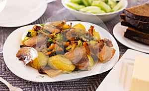 Traditional rustic dish. fried potatoes with chanterelle mushrooms and pork brisket with herbs