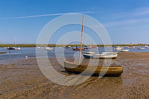 A traditional sail boat on the shore of Brancaster Bay near Burnham, Norfolk, UK