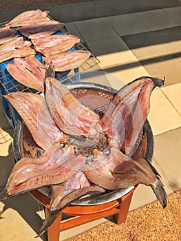 Traditional salted fish drying in stainless steel bowl