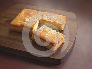 Traditional Salvadoran sweet cheese sponge cake on a dark brown wooden cutting board