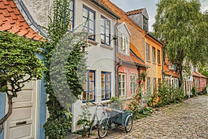 Traditional Scandinavian Cargo bicycle Christiania Bike parked at a house entrance in a cozy street by a colorful facade. Aarhus photo