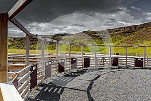 Traditional scandinavian wooden horse stables. With dramatic cloudy sky and colorful sunset on background.