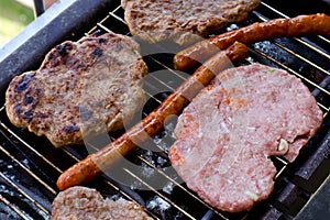 Traditional serbian barbecue rostilj  homemade sausages and burgers. Preparing a barbecue on a grill, outdoor roasting meat. Tra photo