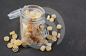 Traditional shape of dry uncooked whole wheat Italian pasta in glass jar