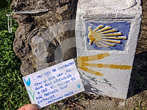 Traditional shell sign and arrow painted on the way. Direction sign for pilgrims in Saint James way, Camino de Santiago