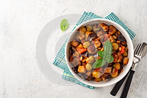 Traditional sicilian eggplant dish Caponata in bowl on concrete background