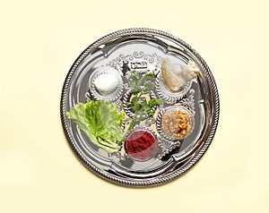 Traditional silver plate with symbolic meal for Passover Pesach Seder on color background