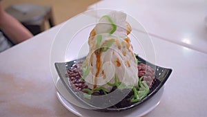 Traditional Singapore called Chendol cold dessert served with coconut, jelly grass and red beans