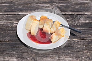 Traditional Slovene Struklji with strawberry jam an white plate, photo