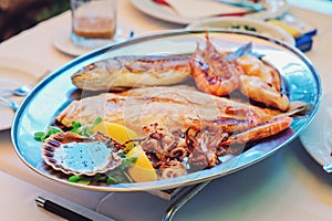 Traditional slovenian cuisine, mixed grilled fish and seafood with garlic oil. Selective focus