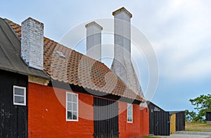 a traditional small,red,danish framehouse in summer in Bornholm with blue sky