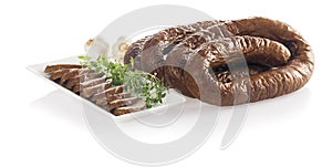 Traditional smoked sausage with slices on plate isolated on whit