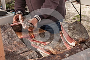 Traditional  smoked speck sliced on site during a celebration in Val di Funes, Dolomites