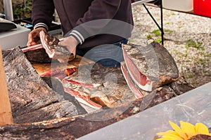 Traditional  smoked speck sliced on site during a celebration in Val di Funes, Dolomites