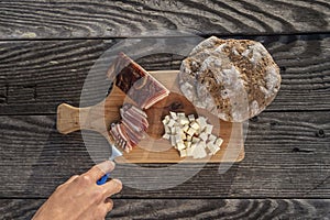 Snack with delicious South Tyrolean smoked bacon and cheese with flat bread lying on a rustic table