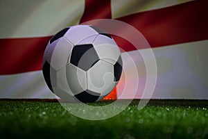 Traditional soccer ball on soccer field. Close up view of soccer ball (football) on green grass with dark toned foggy background.