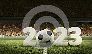 Traditional soccer football ball on grass of football field between huge numbers 2023 at crowded stadium with spotlight