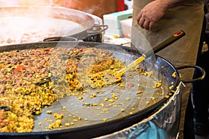 Traditional spanish chicken paella on big pan, food market photo