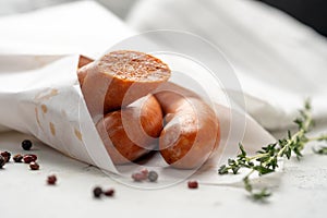 Traditional Spanish Chistorra sausages wrapped in paper with pepper photo