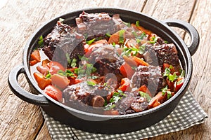 Traditional spanish dish slow cooked oxtail in red wine sauce with rabo de toro closeup on a pot on the table. Horizontal