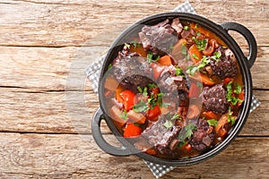 Traditional spanish dish slow cooked oxtail in red wine sauce with rabo de toro closeup on a pot on the table. Horizontal top view