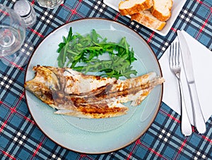 Fresh baked fish sea bass with arugula photo