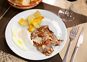 Traditional spanish fried pork with potato and egg on plate. Cerdo patata eggs photo