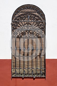 Traditional spanish picturesque barred window with blind. Vertical