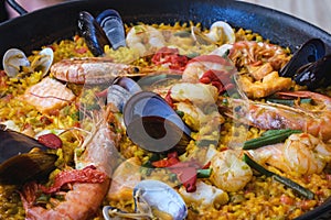 Traditional spanish seafood paella dish in a black pan. Mussels, Amandi and prawns on a pillow of rice. Close-up.