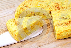Traditional spanish tortilla on a wooden table. Typical dish made with eggs, potatoes and onion