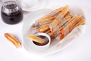 Traditional Spanish treat street fast food churros on a plate with hot chocolate sauce