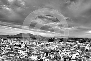 Traditional Spanish whitewashed village with mountain and ruined castle on the sumit. Monochrome black and white