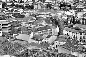 Traditional Spanish whitewashed village with mountain and ruined castle on the sumit. Monochrome black and white