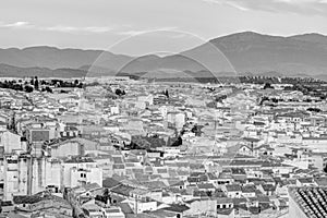 Traditional Spanish whitewashed village with mountain and ruined castle on the sumit. Monochrome black and white