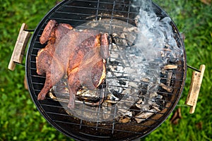 Traditional spatchcocked barbecue chicken al mattone on charcoal grill photo