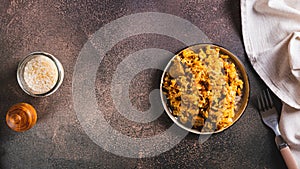 Traditional spicy pilaf with rice and meat on a plate on the table top view web banner